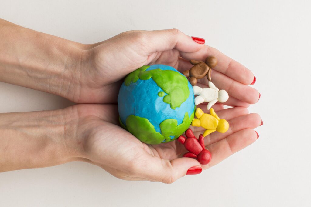 top-view-hands-holding-plasticine-globe-people